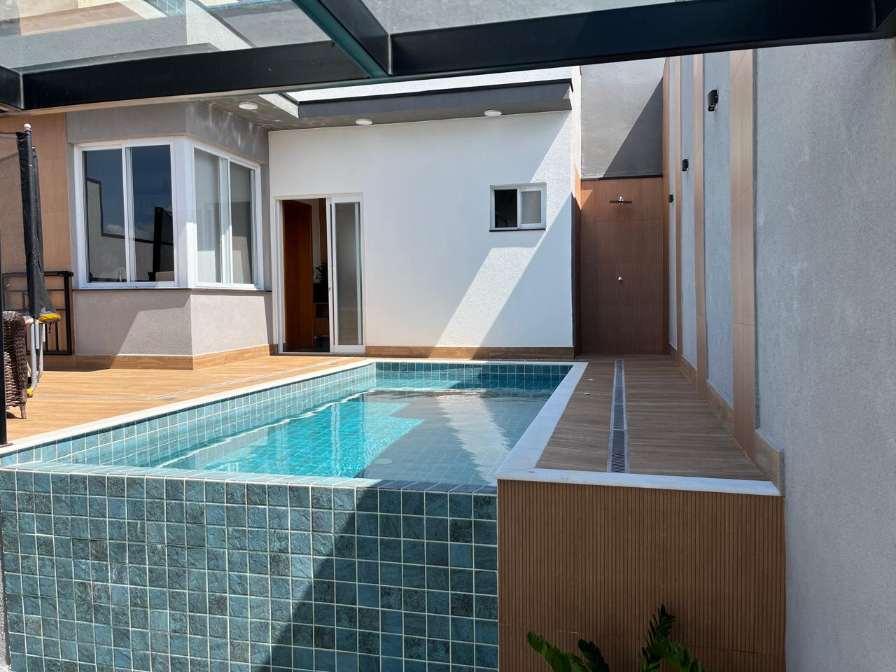 Piscina aquecida com deck e cobertura de vidro